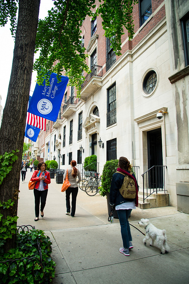 Campus 032 Woman walking her dog and people walking in different directions outside of Marymount Manhattan College 71st Street Building