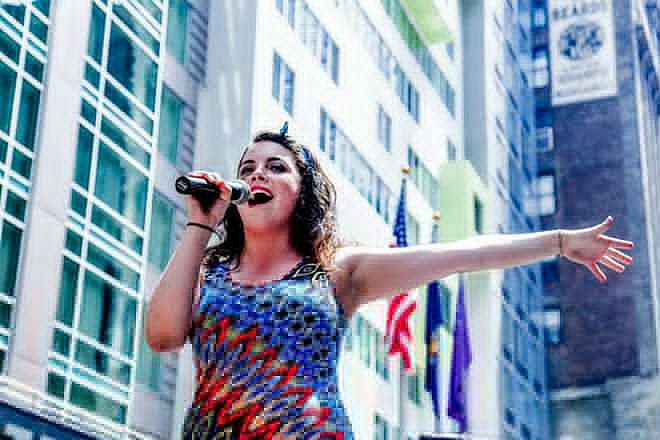 Alumnus Melissa Rose Hirsch singing on a float during the New York City Pride Parade.